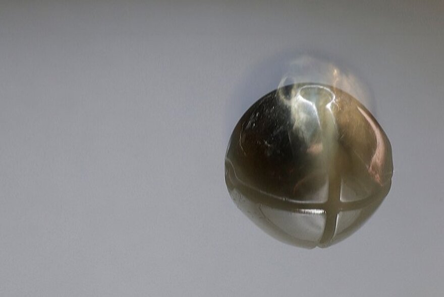 Brass pin on grey background.