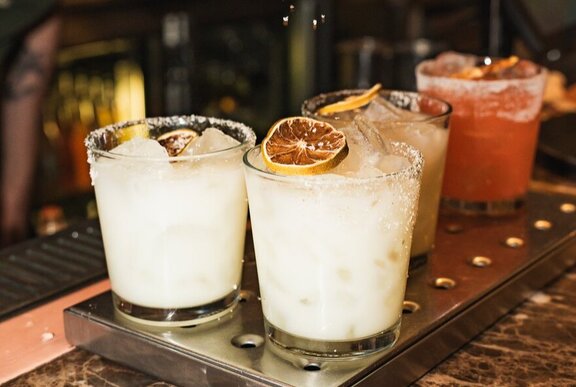 Assorted flavoured margaritas cocktails on a bar.