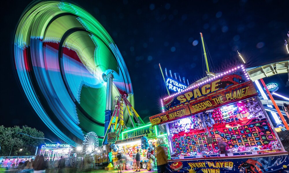 A carnival at night with rides and games.