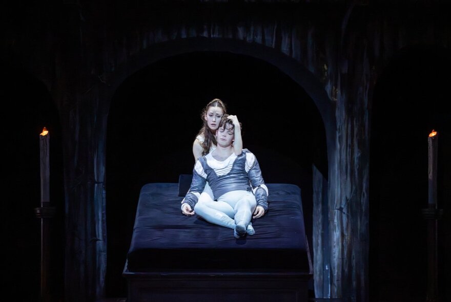 Two classical ballet dancers on stage during a performance of Romeo and Juliet by The Australian Ballet; Juliet cradling a dying Romeo in her arms.
