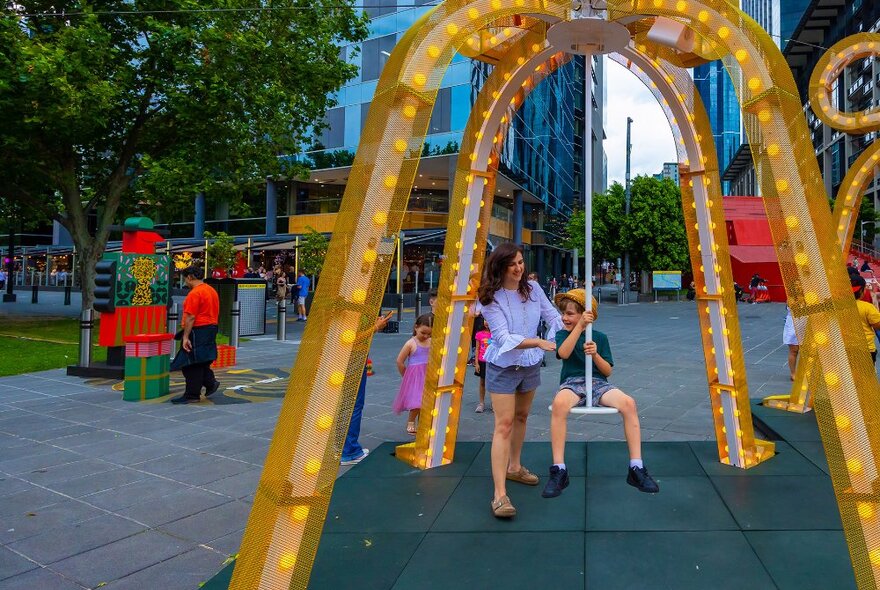 A family using a swing in a city. 