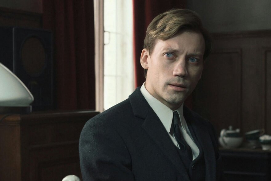 Man wearing a suit looking quizzical.