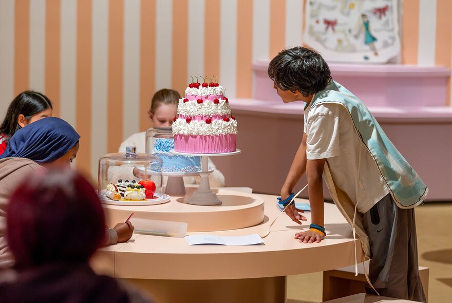 Kids drawing pictures of model cakes.