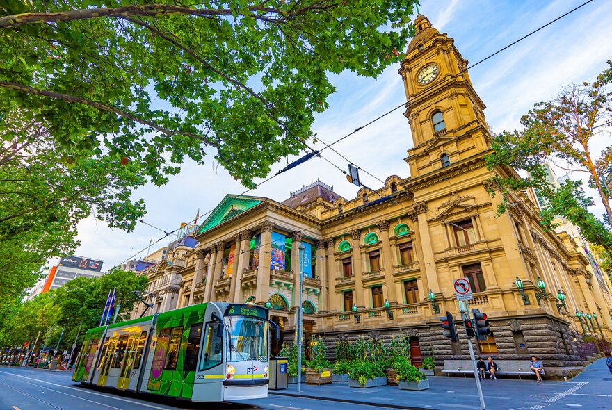 A tram is going past the Melbourne Town Hall
