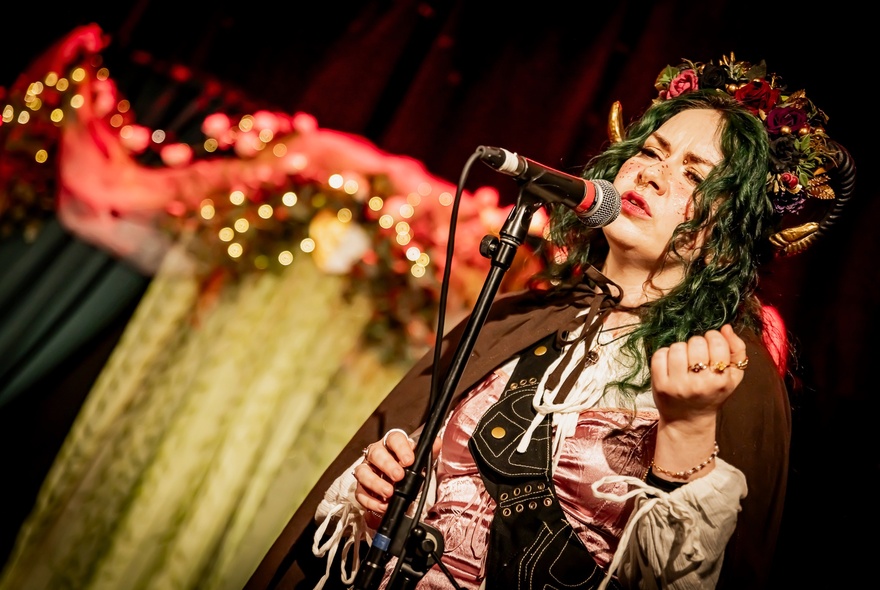 A woman on a fantasy costume speaking into a microphone. 
