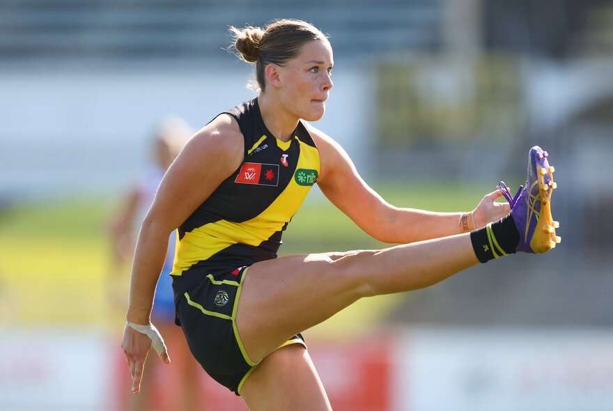 Richmond AFLW football player kicking the ball.