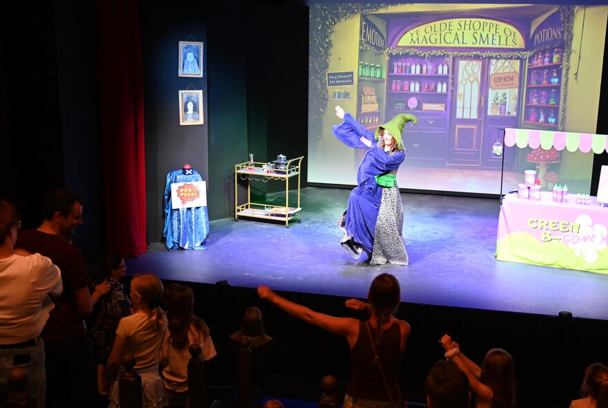 Winni Wizard, a kids comedian, performing on stage in front of an audience of children.