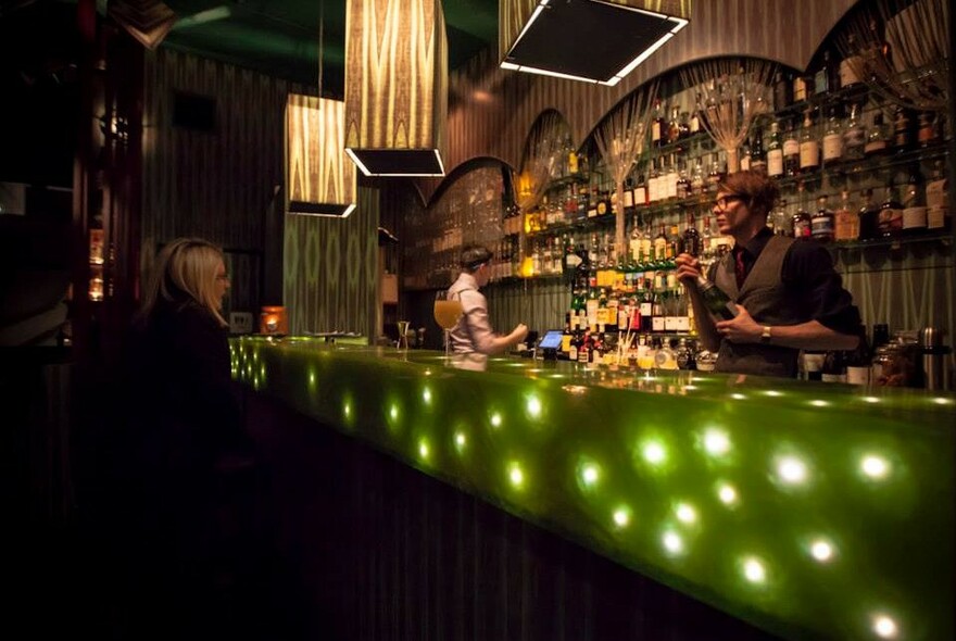 Dimly lit bar with a decorative green light display.