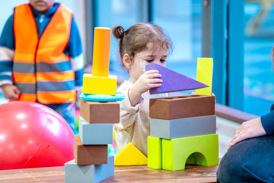 A child playing with large foam building blocks.