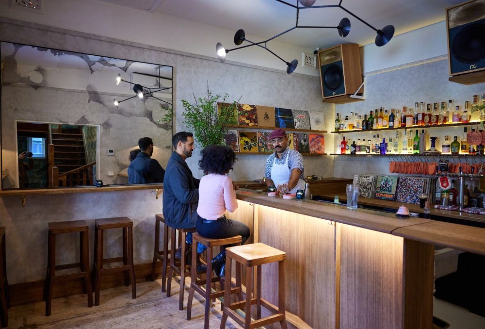 A couple sitting at a bar being served.