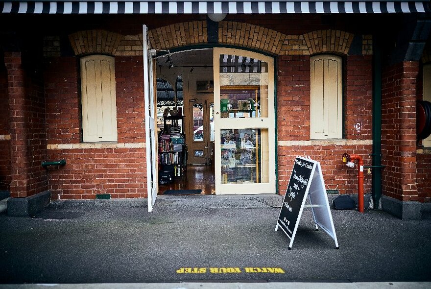 Victoria Street frontage with pavement, awning, shuttered windows and door opening into the store.