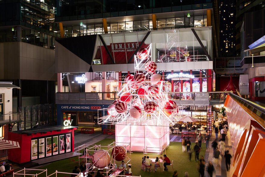 A giant metal Christmas tree installation with large red baubles.