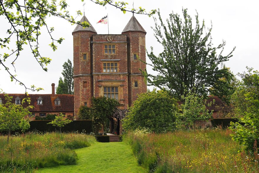 Sissinghurst Castle in the background set in a lush green garden.