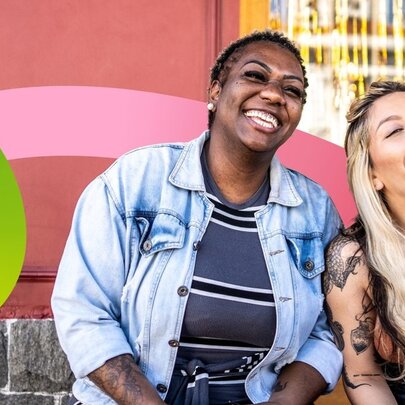 Two individuals smiling and enjoying a sunny day outdoors, with a curved green and pink stripe overlaid over the image.