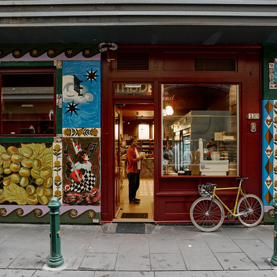 The exterior of a deli with street art painted on the walls.