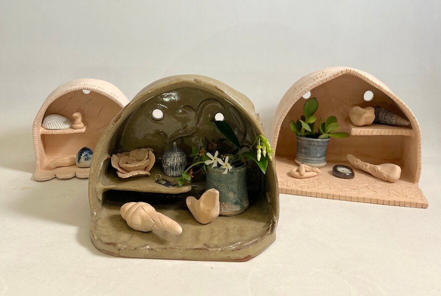 Wooden miniature shrines containing special objects.