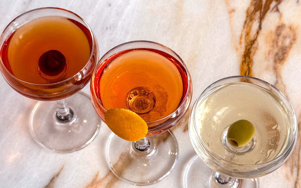 Three martinis with different colours and garnishes.