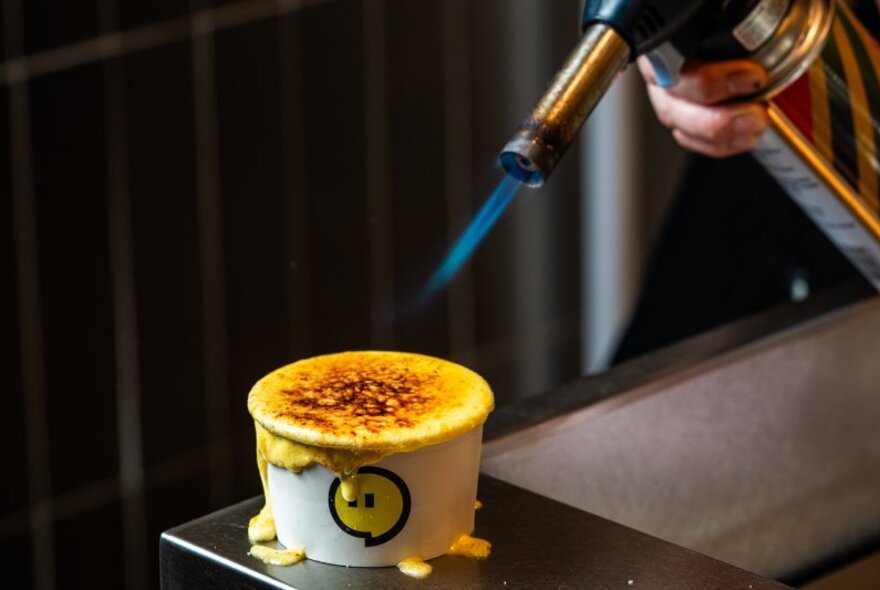 Blowtorching the top of a gelato cup, brulee style.