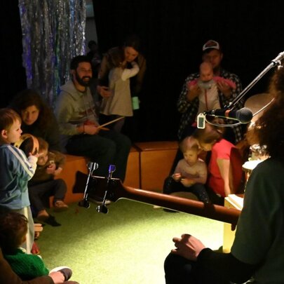 Children playing with adults with musical instruments.