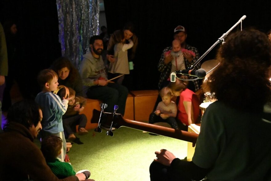 Children playing with adults with musical instruments.