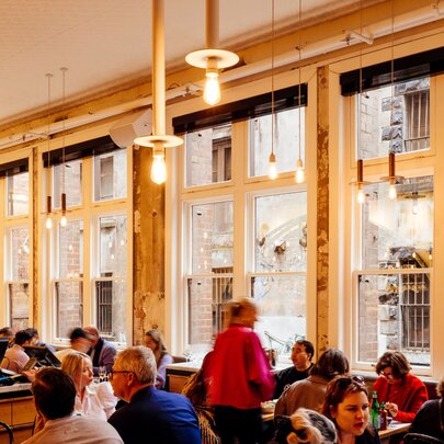 The interior of Chin Chin restaurant, with full tables of patrons in front of a wall of windows.