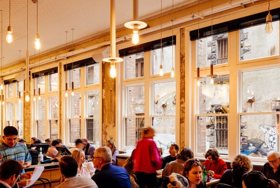 The interior of Chin Chin restaurant, with full tables of patrons in front of a wall of windows.