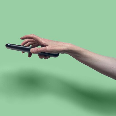 An outstretched hand holding a remote.
