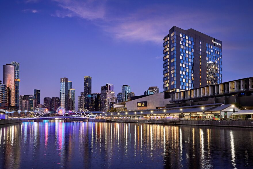 A view of Melbourne's Yarra River at night with city lights reflecting on the water. 