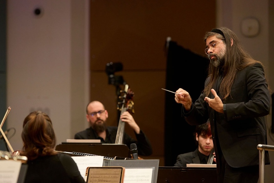 A conductor and some musicians of the Melbourne Symphony Orchestra rehearsing.