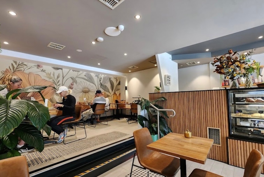 Cafe interior with raised seating area and wooden detailing.