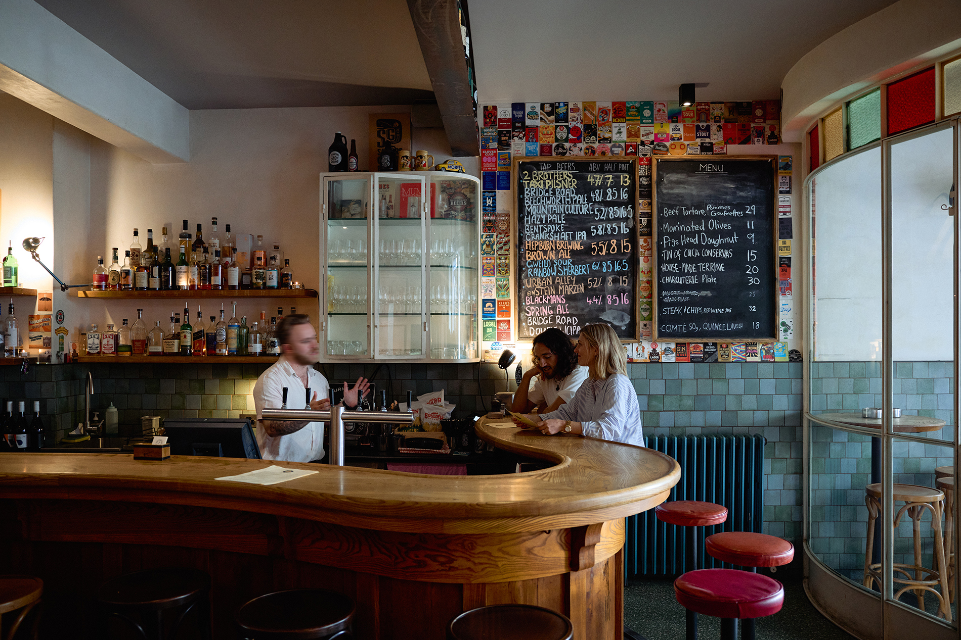 A couple sitting at the bar of a pub.