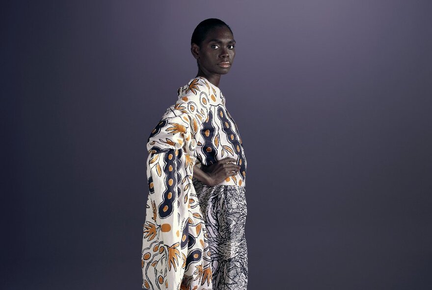 An Indigenous model wearing a boldly patterned dress.