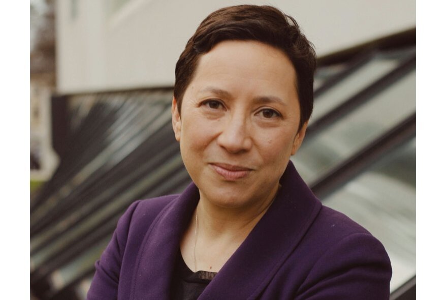 Louisa Lim, with short dark hair, wearing a purple top.