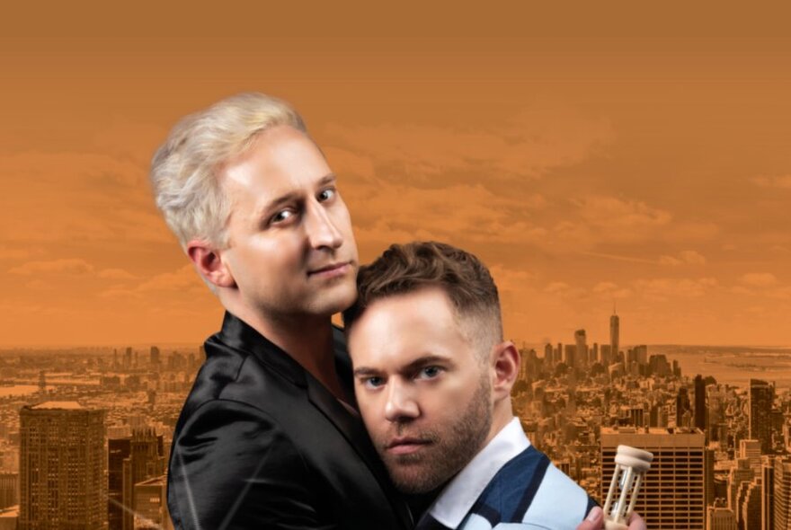 Two men in an embrace, holding an egg timer, against an orange backdrop of Melbourne.
