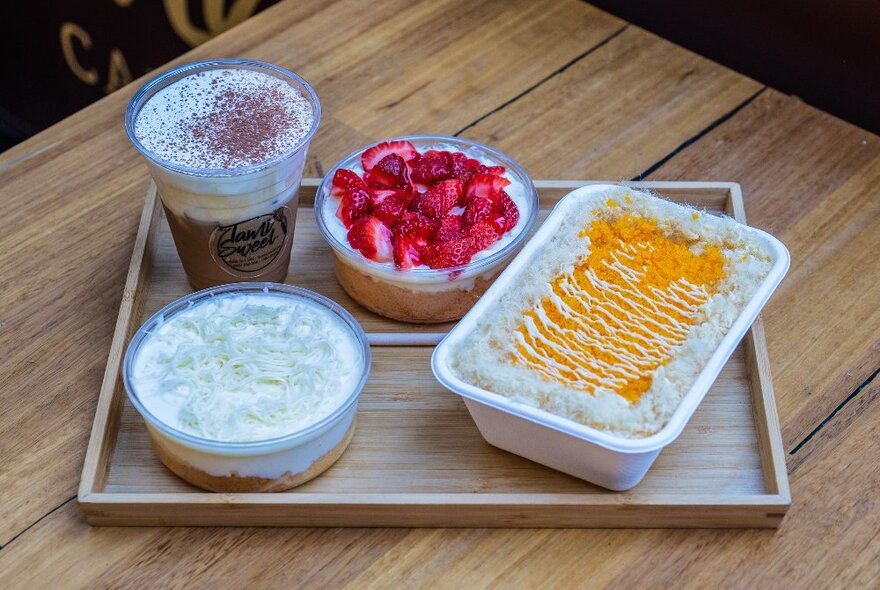 A tray with desserts and iced coffee on it