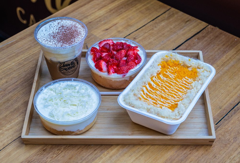 A tray with desserts and iced coffee placed on top.