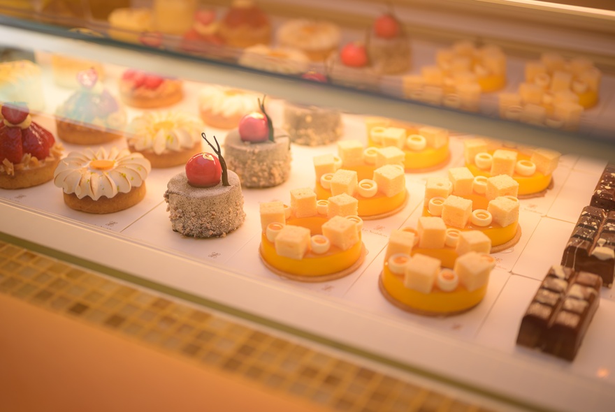 Rows of fruit-based cakes on display, with strawberries and mango.