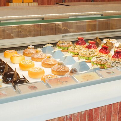 Full patisserie window with many varieties of cakes on display. 