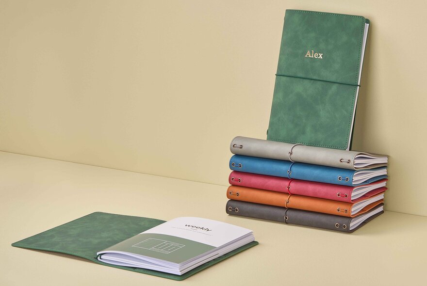 Small stack of different coloured journals.