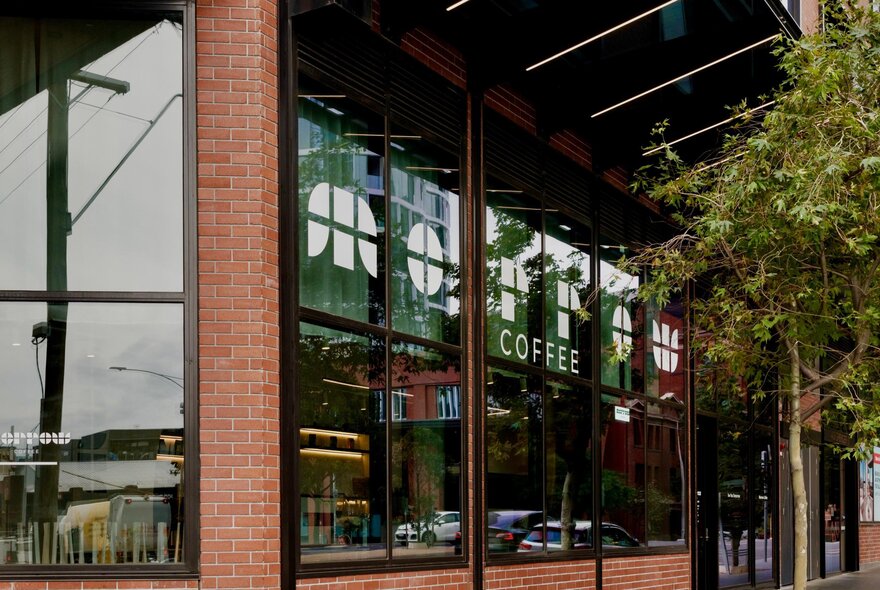 The external shopfront of Morrow Cofee, with a streetscape reflected in its windows.