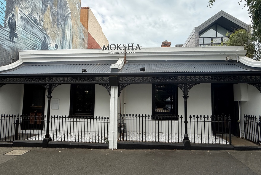 The double fronted Edwardian facade of Indian restaurant, Moksha, with wrought iron latticework and two front doors.