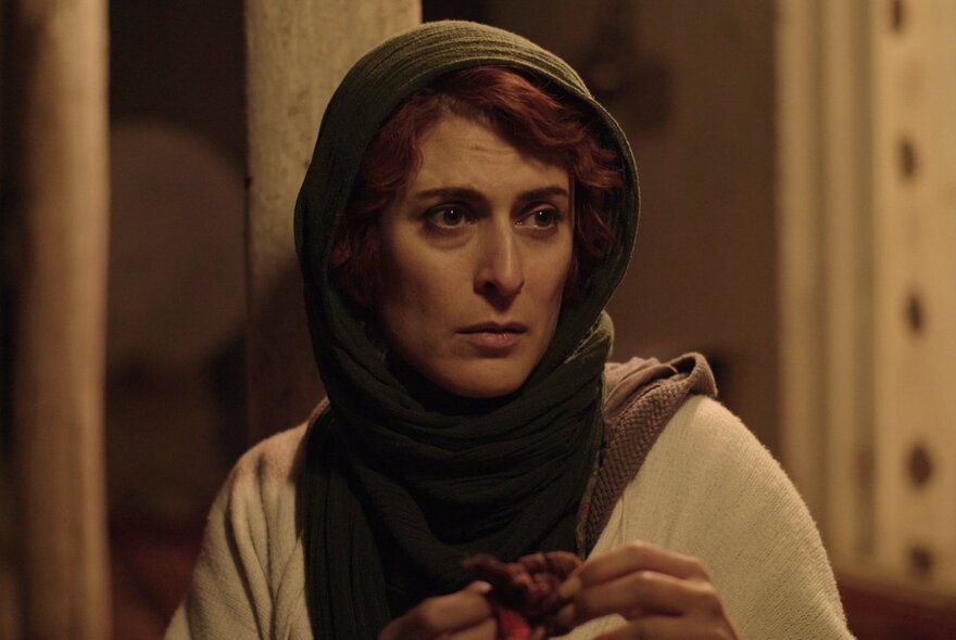 A still from an Iranian movie showing a woman with a scarf over her hair.