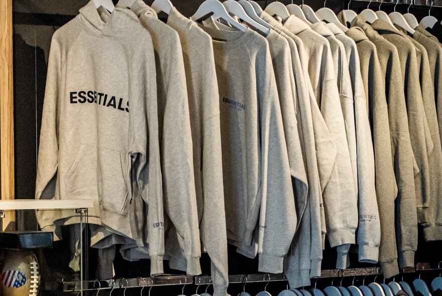 Rows of hooded sweatshirts on hangers.
