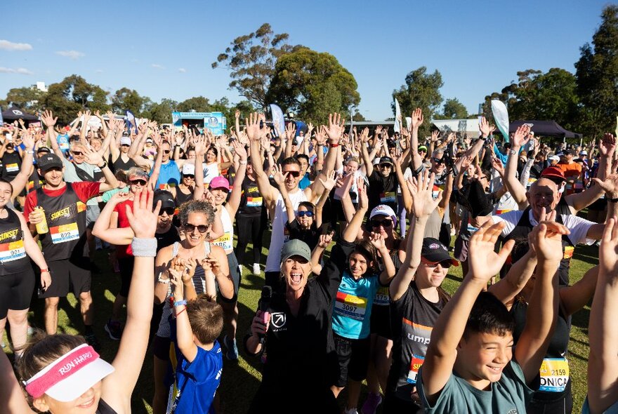 A large group of runners warming up before taking part in a race around Melbourne Zoo. 