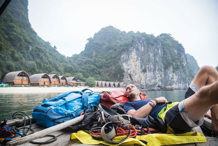 Person on a boat with ropes and backpack.