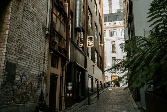 A bluestone alley in Melbourne, with a sign above a building that reads CODA.