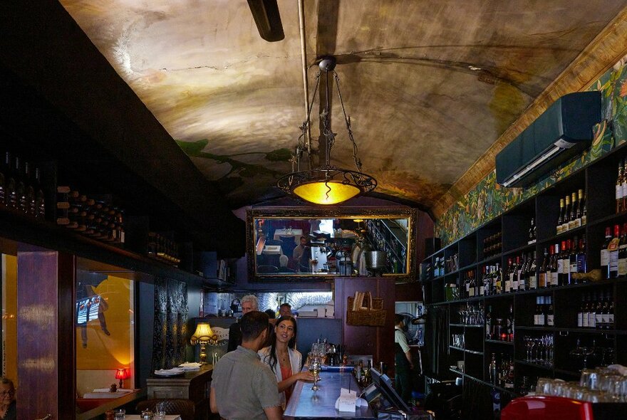 A couple are drinking wine in a French-style restaurant