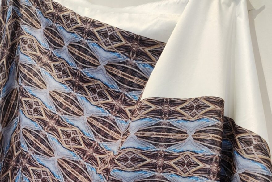 Patterned fabric draped with plain white cloth. 