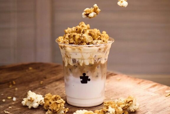 An iced latte with popcorn on top.
