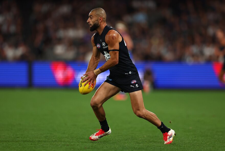 Carlton AFL football player on the field during a match.